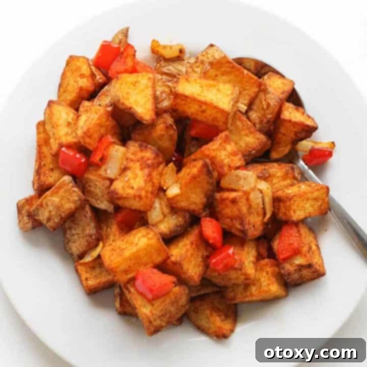 Crispy air fryer breakfast potatoes on a white plate, ready to be served.