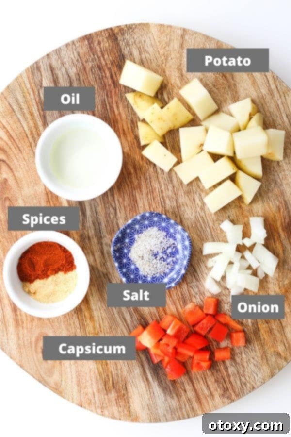Various recipe ingredients including potatoes, bell pepper, onion, and spices arranged on a wooden board.