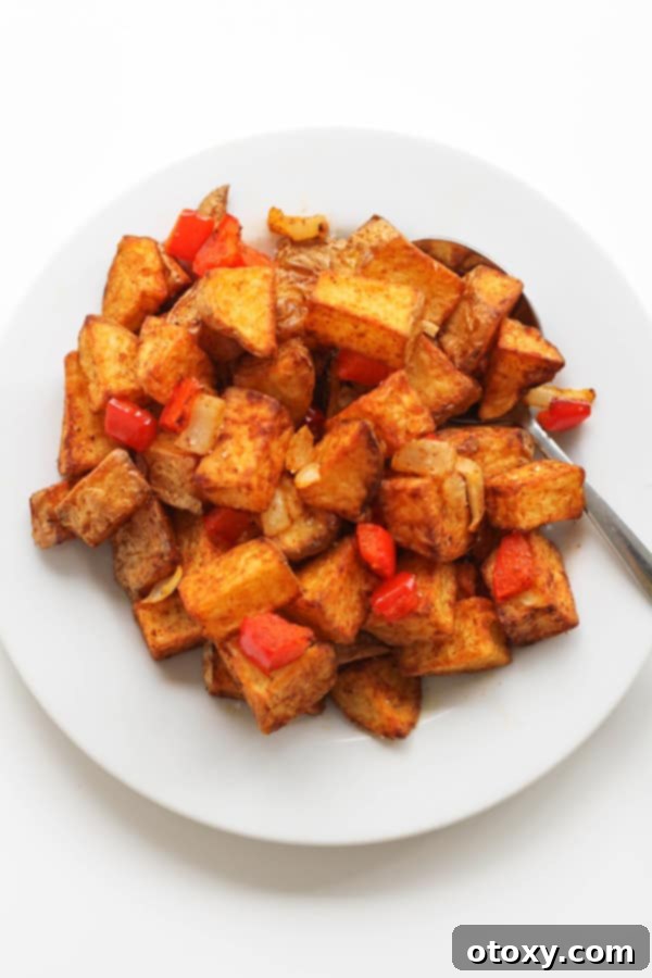 A beautifully arranged plate of crispy breakfast potatoes, garnished for a perfect morning meal.