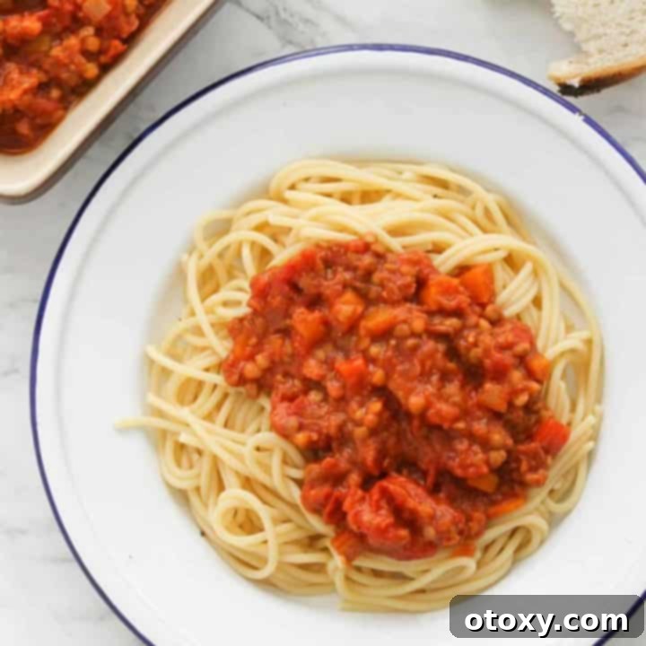 Delicious vegetarian lentil bolognese served on a white plate with spaghetti.