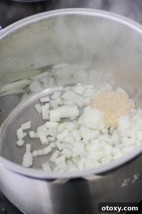 Diced onions and minced garlic gently sautéing in olive oil in a saucepan.