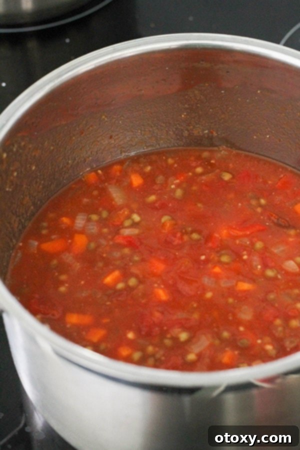 A rich, thick vegetarian bolognese sauce simmering gently in a large pot, bubbling with flavor.