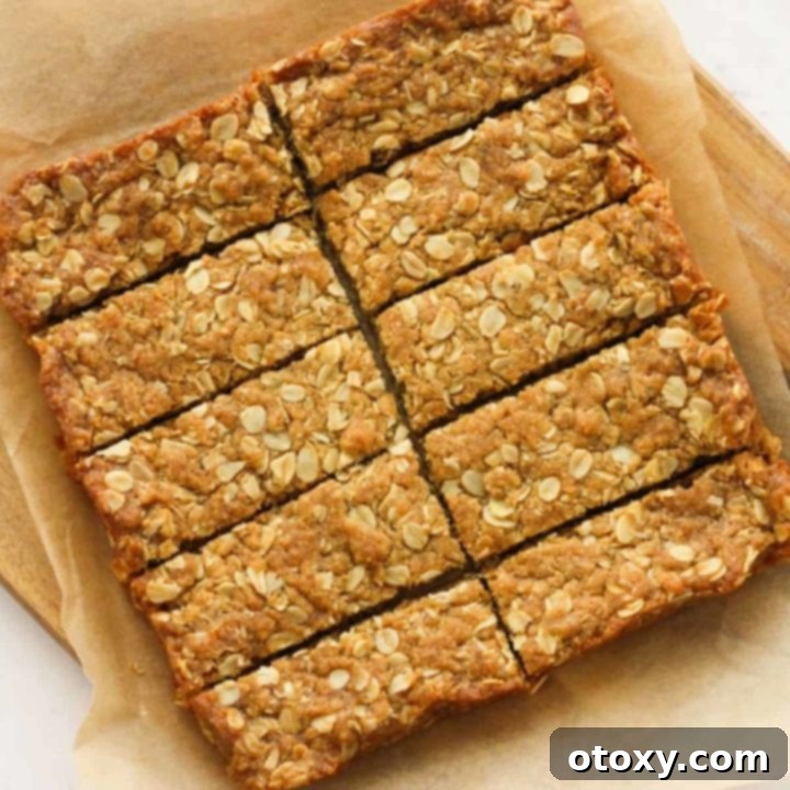 Anzac Golden Oat Bar 11 Anzac slices neatly arranged on a wooden board, ready to be served and enjoyed.
