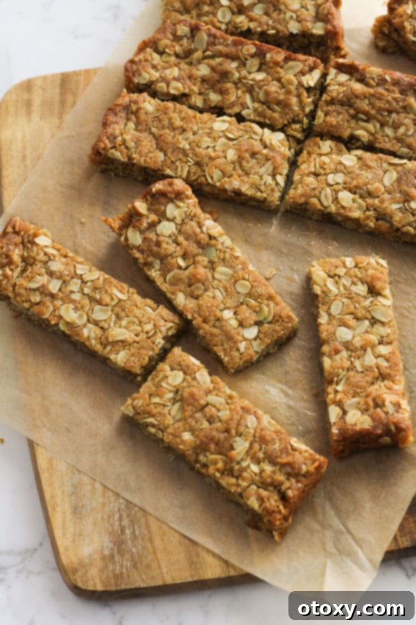 Anzac Golden Oat Bar 9 Perfectly baked Anzac slice pieces neatly arranged on a wooden board, showcasing their golden color and inviting texture, ready for serving.