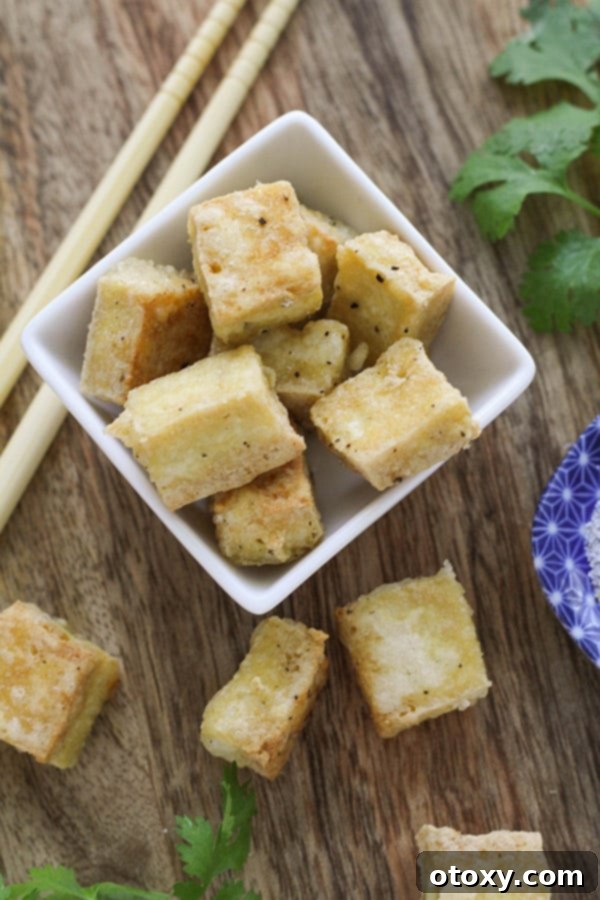 Golden Crispy Salt and Pepper Tofu 2 Crispy salt and pepper tofu bites arranged neatly in a square white bowl, ready to be served.