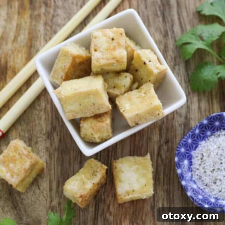 Golden Crispy Salt and Pepper Tofu 9 Crispy Salt and Pepper Tofu bites in a square bowl, ready to serve.