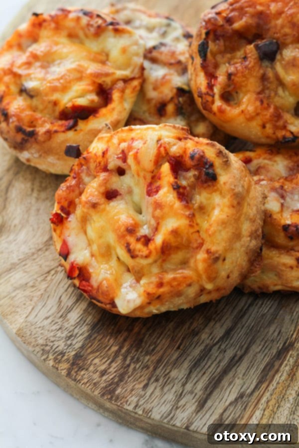 A stack of golden vegetarian pizza scrolls on a rustic wooden cutting board.