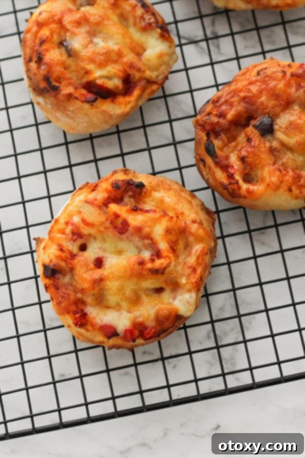 Freshly baked vegetarian pizza rolls resting on a wire cooling rack.