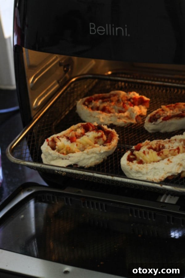 Vegetarian pizza rolls arranged in an air fryer basket, ready to cook.