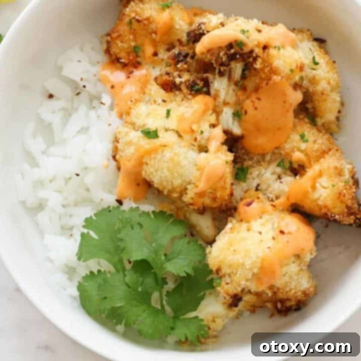 Crispy Bang Bang Cauliflower Oven and Air Fryer 13 Crispy Bang Bang Cauliflower served over a bed of fluffy white rice, garnished with fresh herbs.
