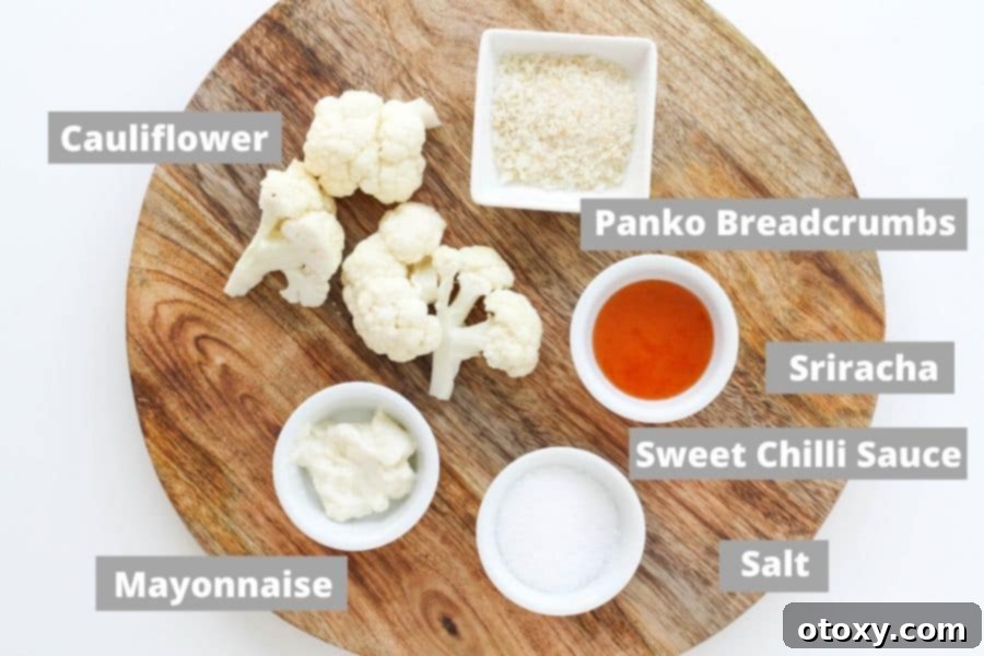 Crispy Bang Bang Cauliflower Oven and Air Fryer 3 A selection of fresh ingredients laid out on a wooden board, including cauliflower florets, mayonnaise, sweet chili sauce, sriracha, and panko breadcrumbs.