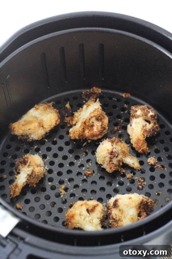 Crispy Bang Bang Cauliflower Oven and Air Fryer 10 Perfectly golden and crispy Bang Bang Cauliflower pieces, fresh from the air fryer, nestled in its basket.