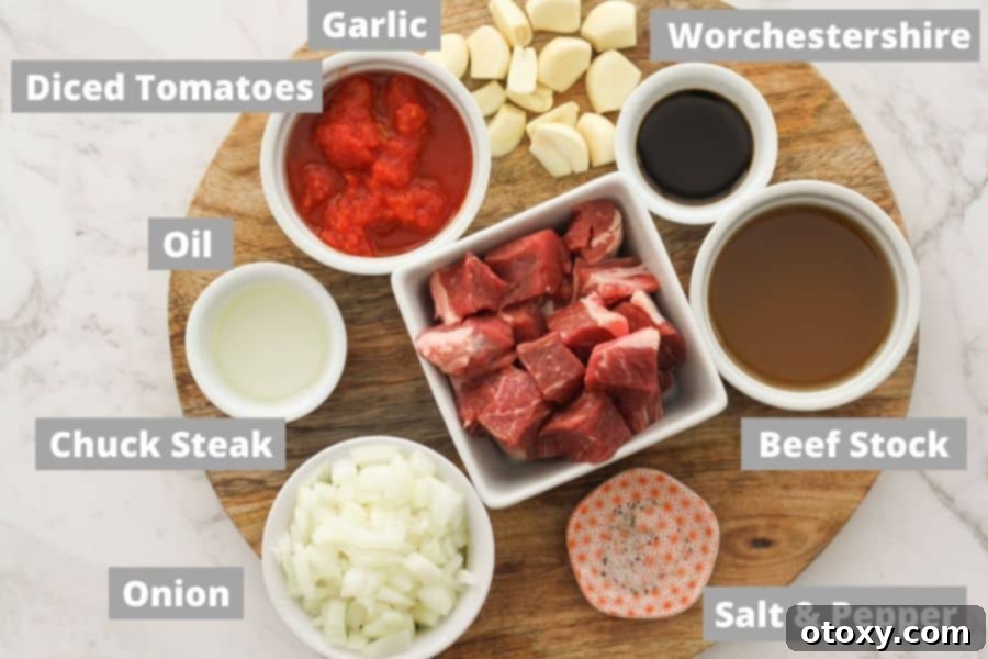 braised beef ingredients laid out on a wooden board: olive oil, beef, onion, diced tomatoes, garlic, Worcestershire sauce, beef stock, salt, and pepper.
