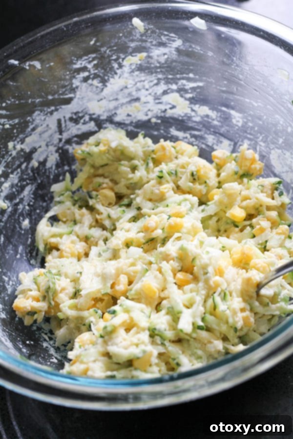 fritter ingredients mixed together in a glass mixing bowl.