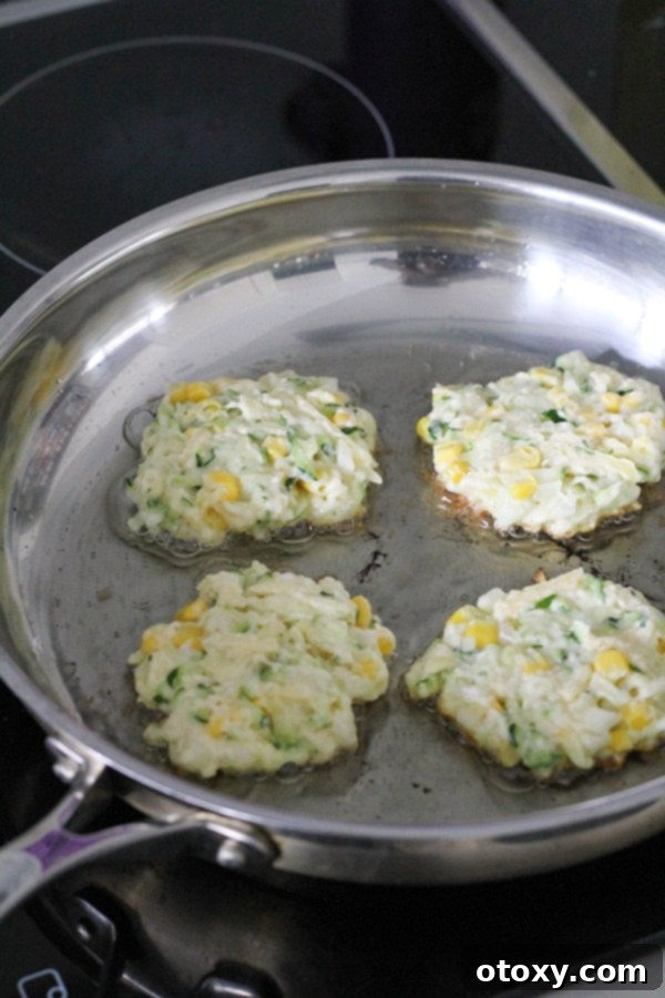 fritters cooking in a frying pan.