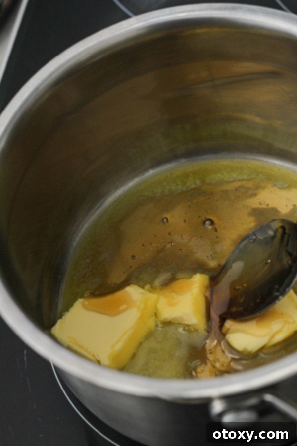 Easy Honey Roasted Peanuts in Your Oven or Air Fryer 4 Honey and butter melting together in a small saucepan over medium heat, forming a glossy golden mixture.