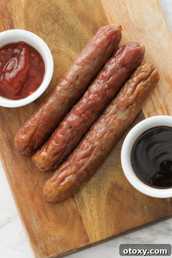 A selection of perfectly cooked sausages arranged on a rustic wooden serving board.