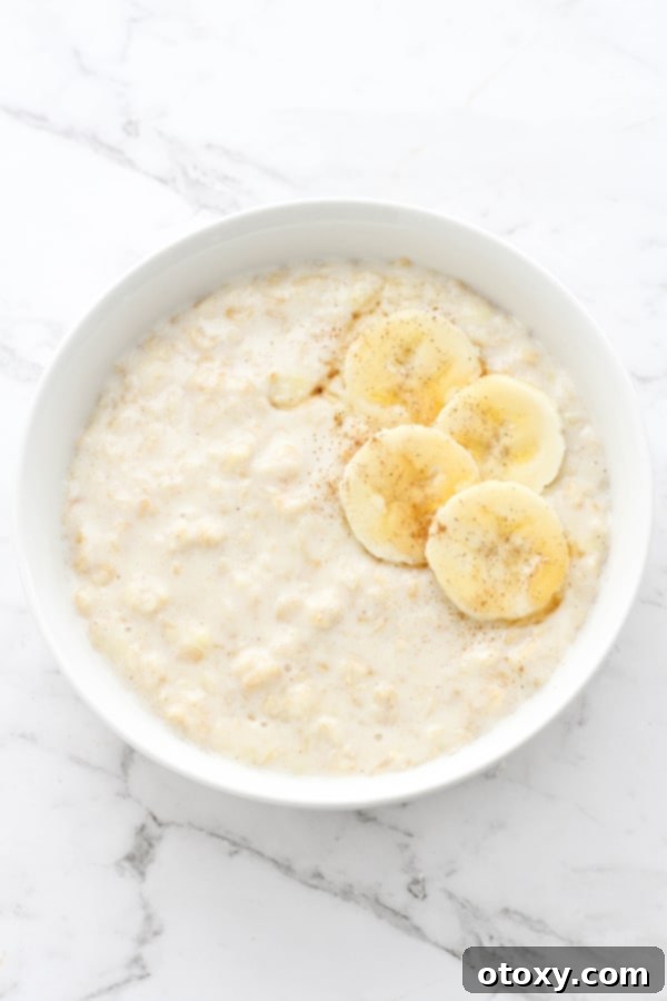Golden Banana Breakfast Bowl 2 A warm bowl of creamy banana porridge, topped with fresh banana slices, ready to be enjoyed on a cold morning.