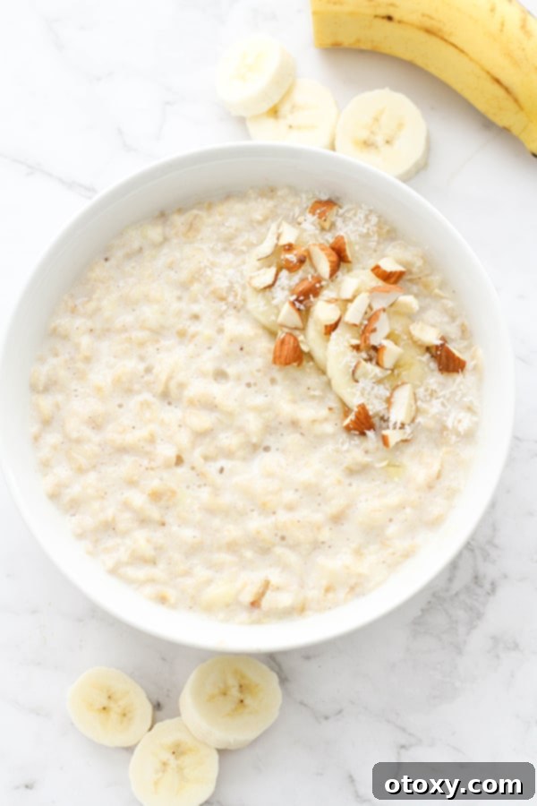 Golden Banana Breakfast Bowl 3 A beautifully arranged bowl of banana porridge, topped with fresh banana slices, a sprinkle of cinnamon, crunchy almonds, and delicate coconut flakes.