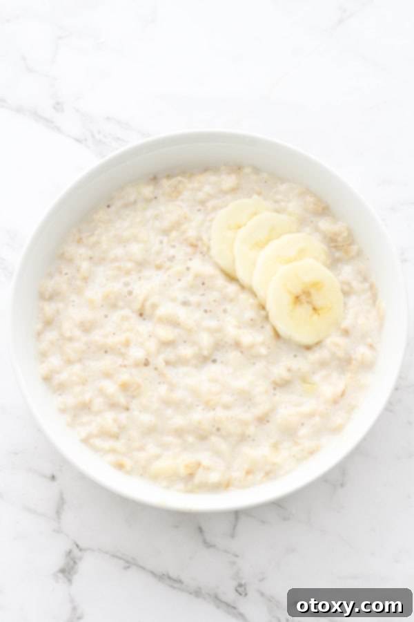 Golden Banana Breakfast Bowl 7 A pristine white bowl filled with creamy banana porridge, artfully garnished with fresh banana slices, ready to be enjoyed.