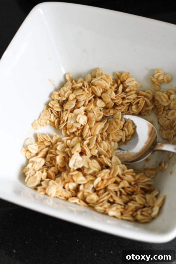Bowl of apple crisp topping ingredients, showing oats, flour, and butter mixed together.