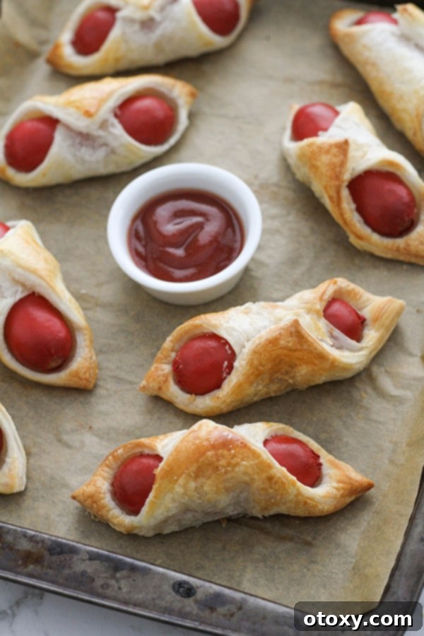 Crispy Air Fryer Sausage Bites 9 Air Fryer Pigs in a Blanket on a baking tray after cooking, ready to be served.