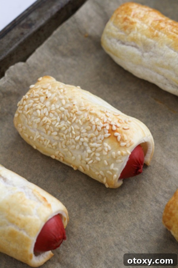 Golden-brown puffy dogs cooked in an air fryer, displayed in the air fryer basket.