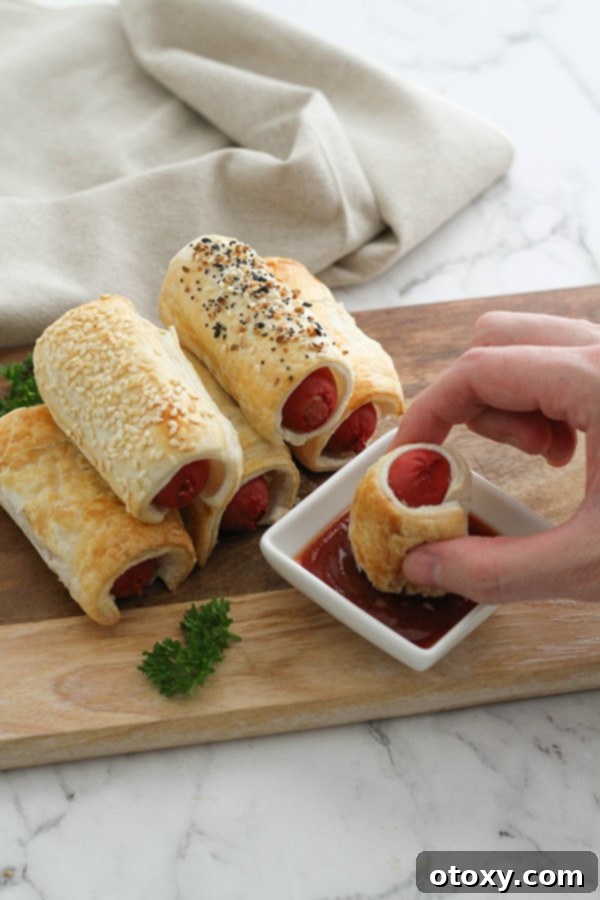 A stack of golden, flaky puffy dogs presented beautifully on a wooden serving board, inviting enjoyment.