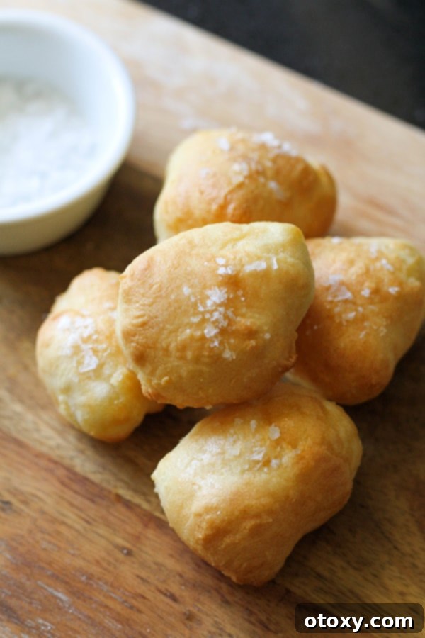 Appetizing two-ingredient dough pretzel bites, perfectly stacked on a wooden serving board, ready to be enjoyed as a snack or appetizer.