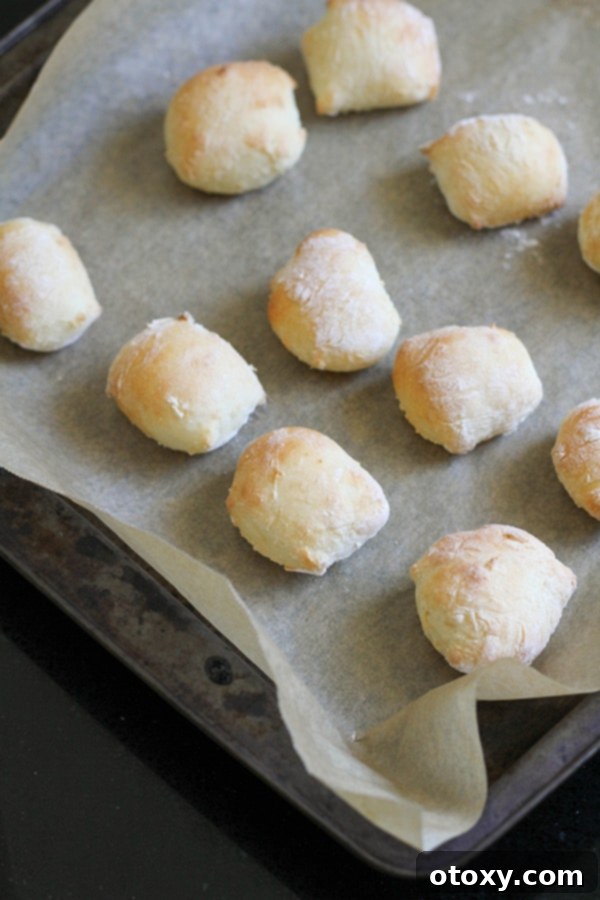 Golden brown, cooked pretzel bites fresh out of the oven, arranged neatly on a baking tray lined with parchment paper.