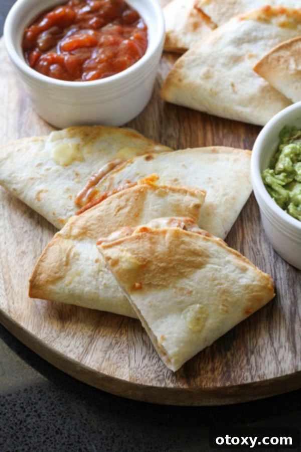 quesadilla quarters on a wooden board with guacamole and salsa. 