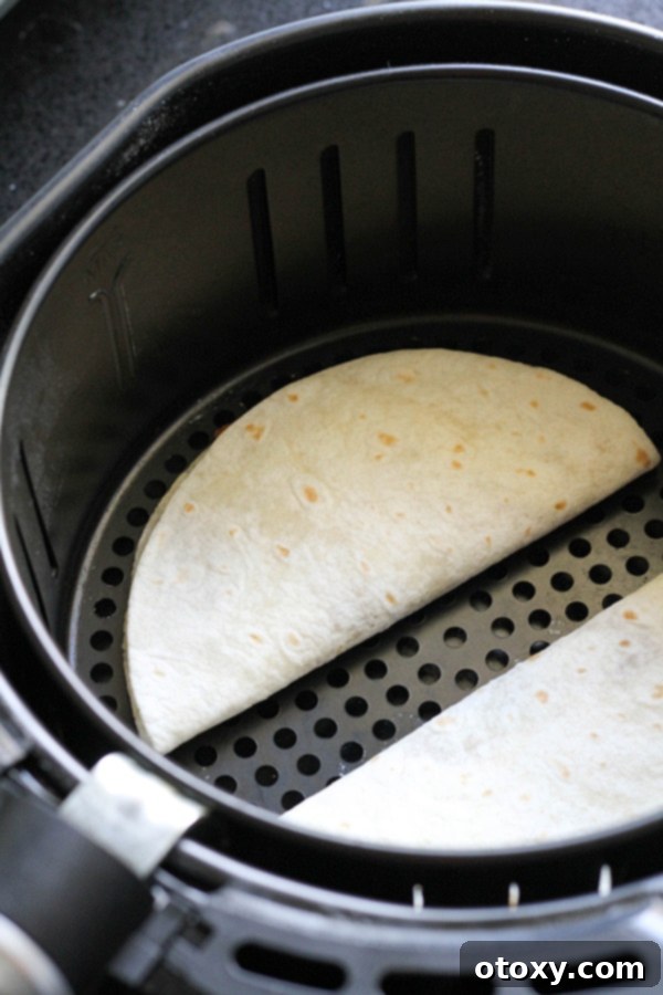 quesadillas in an air fryer basket ready to be cooked.
