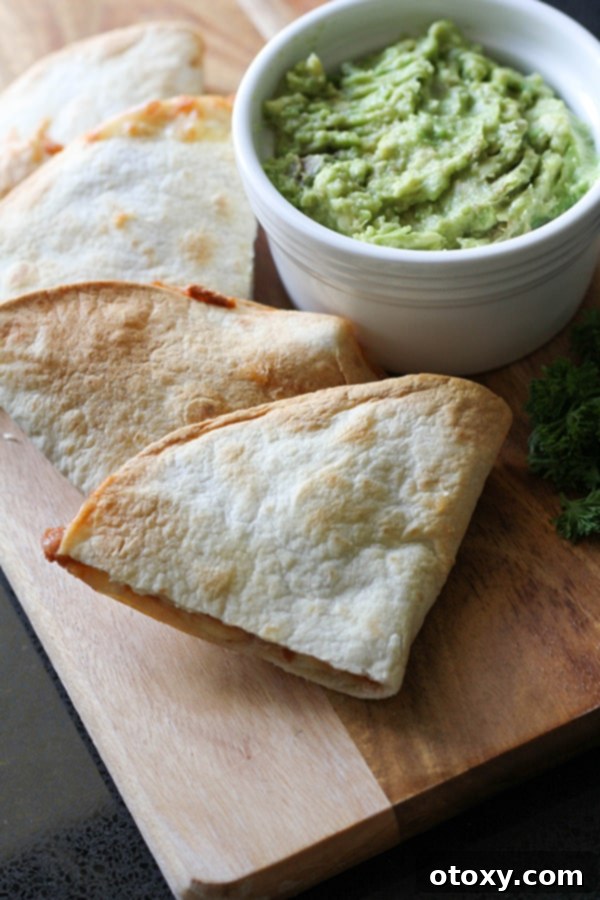 quesadilla quarters on a wooden board with a bowl of guacamole.