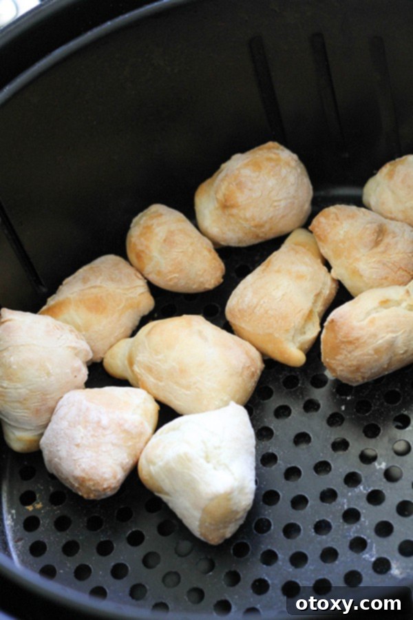 Golden brown pretzel bites neatly arranged in an air fryer basket, showing even cooking.