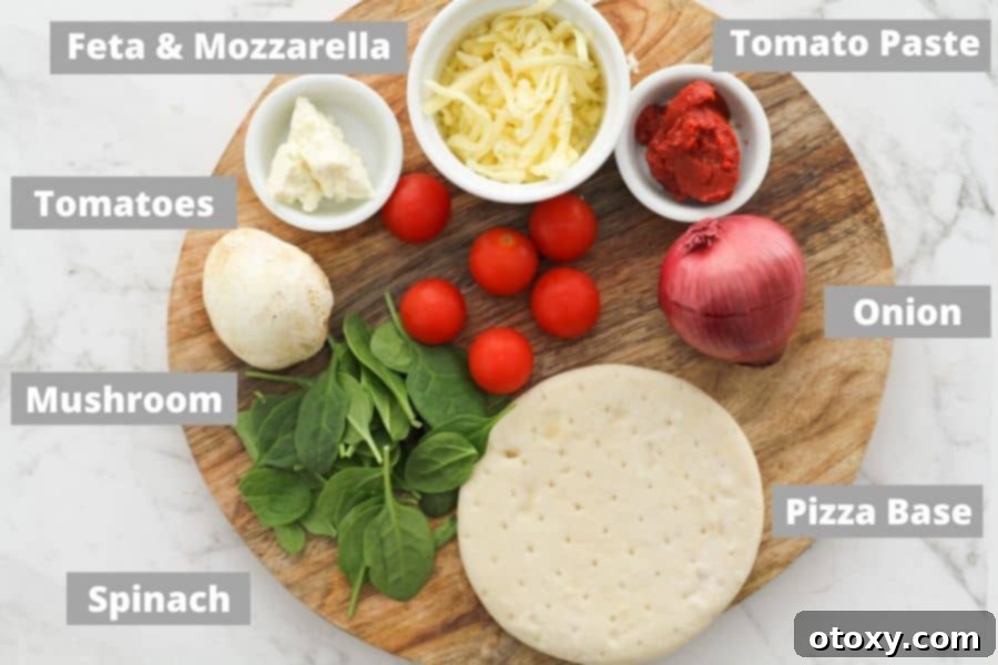 Mediterranean Greens and Feta Pizza 4 Various fresh ingredients for spinach and feta pizza laid out on a wooden cutting board.