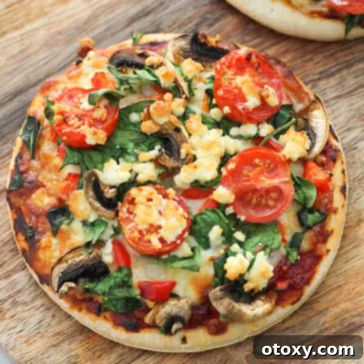 Mediterranean Greens and Feta Pizza 8 Two spinach and feta pizzas on a rustic wooden serving board, garnished with fresh basil.