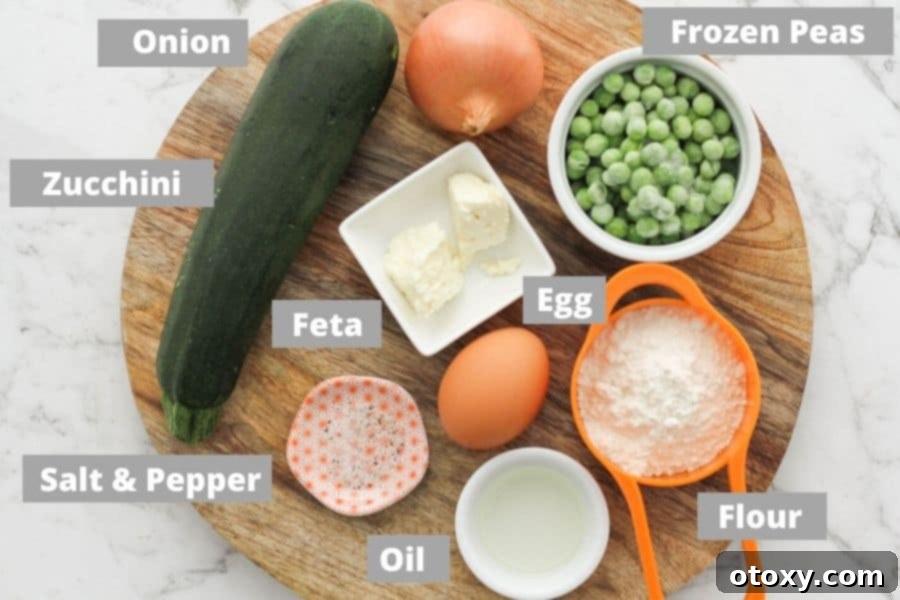 An array of fresh ingredients including zucchini, peas, onion, egg, flour, feta, salt, pepper, and olive oil laid out on a wooden board.