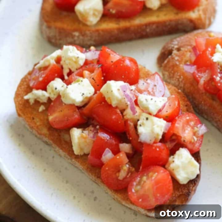 Tomato and Feta Bruschetta on a white plate with balsamic glaze