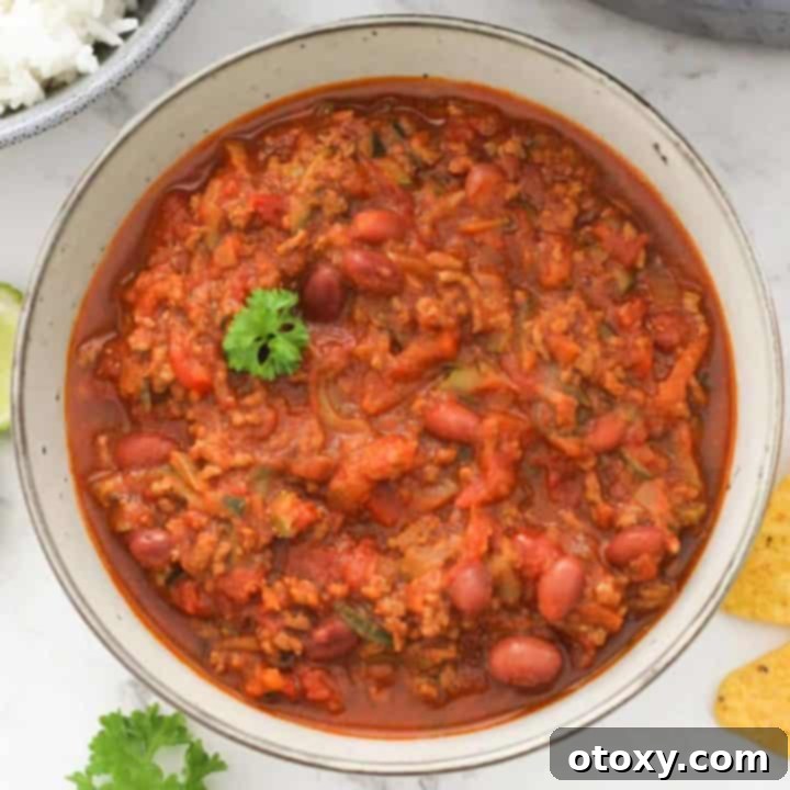 A bowl of healthy Chilli Con Carne topped with fresh parsley, ready to be enjoyed.