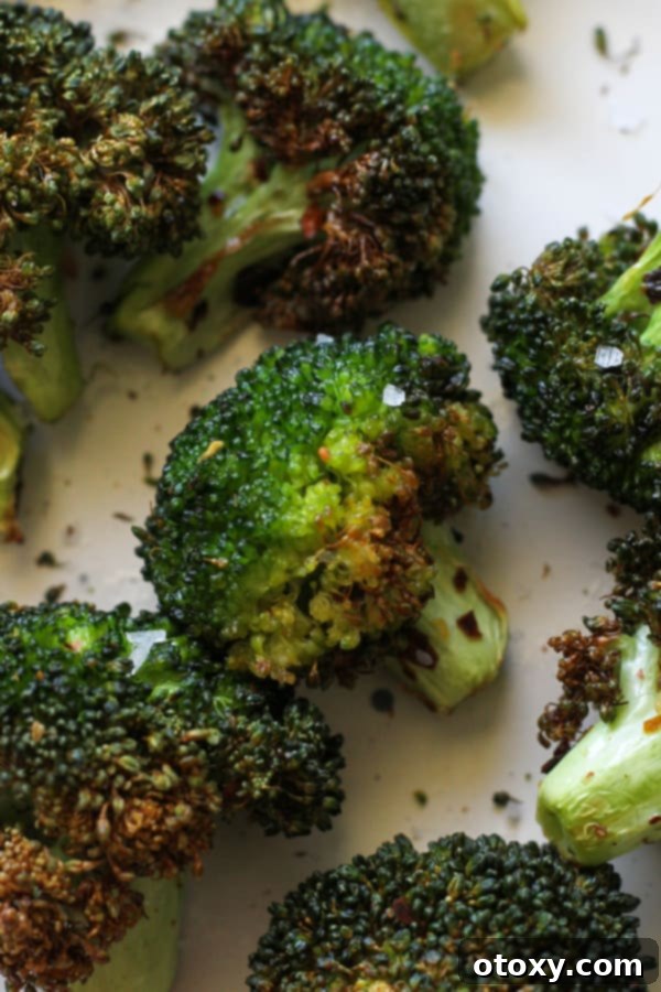 roasted broccoli on a white plate.