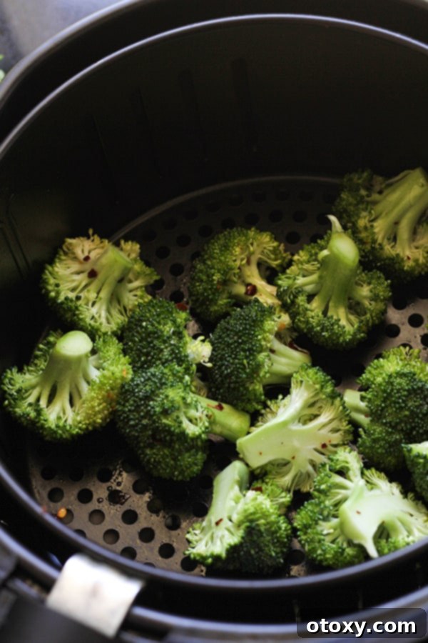 broccoli inside an air fryer basket.