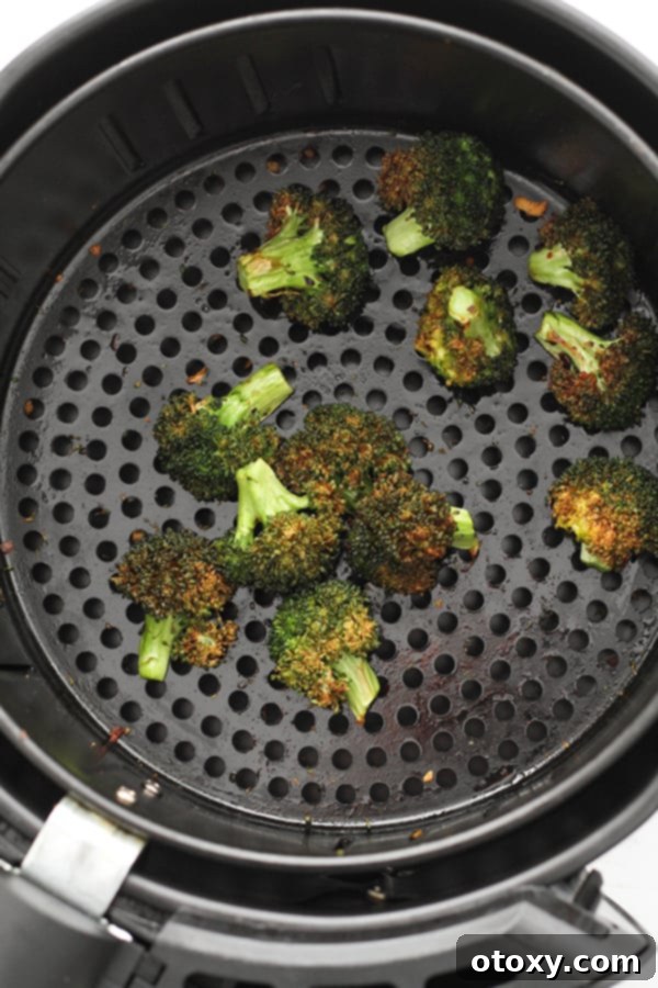 roasted broccoli in an air fryer basket.