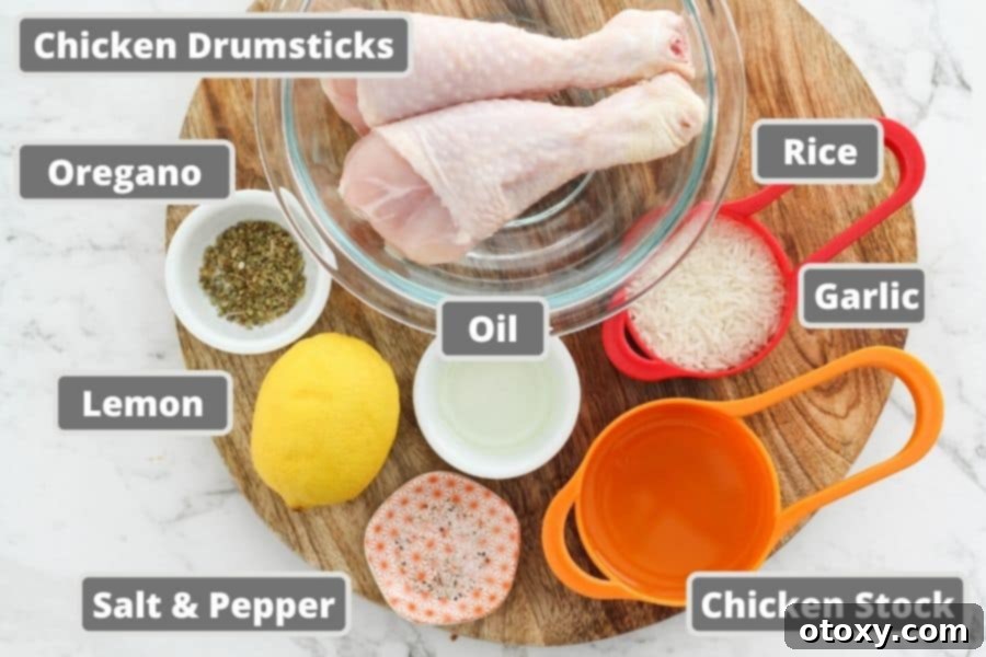 A rustic wooden board displays all the fresh ingredients needed for Greek chicken and rice: raw chicken drumsticks, lemons, garlic, fresh oregano sprigs, olive oil, and a bowl of rice.