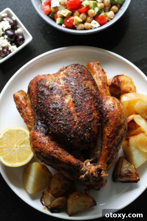 greek roast chicken and potatoes on a white plate.