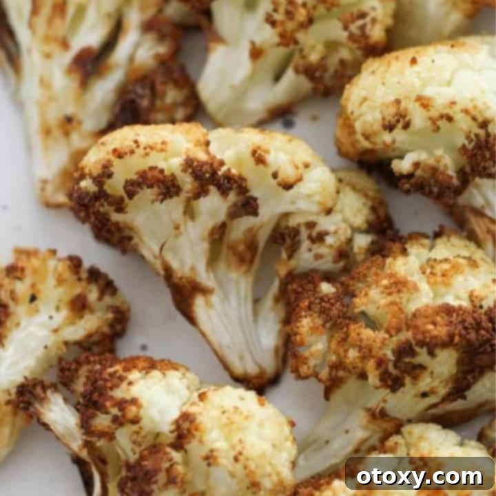 A plate of perfectly roasted cauliflower florets, ready to be served as a delicious side dish.