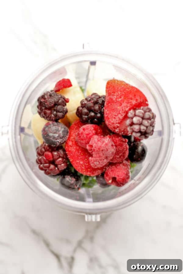 Tropical Burst Smoothie 3 berry green smoothie ingredients in a blender cup