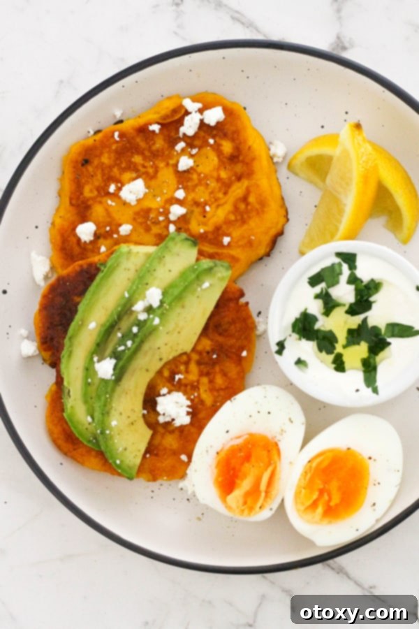 Golden Pumpkin Bites 11 two pumpkin fritters on a white plate topped with feta and avocado.