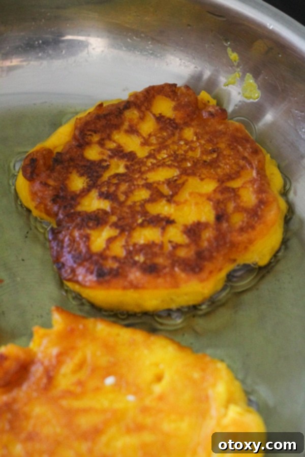 Golden Pumpkin Bites 9 pumpkin fritter being cooked in a frying pan.