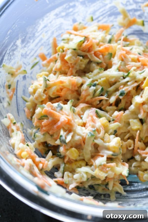 Golden Garden Fritters 7 Fritter batter in a glass bowl, with flour just incorporated, showing a thick consistency.