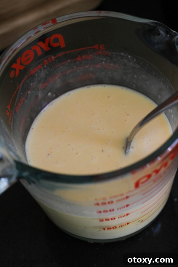 Fresh eggs, heavy cream, salt, and pepper beautifully whisked together in a clear glass jug.